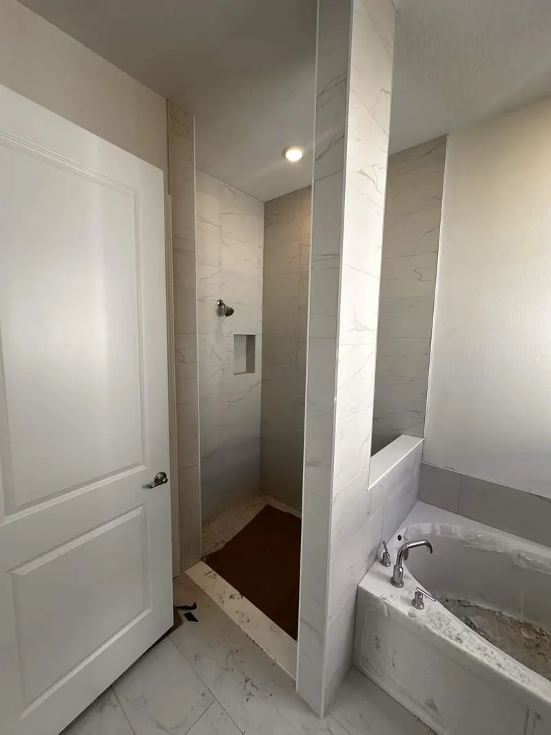 Waterjet-cut marble ogee feature wall with freestanding tub, luxury NE Florida bath