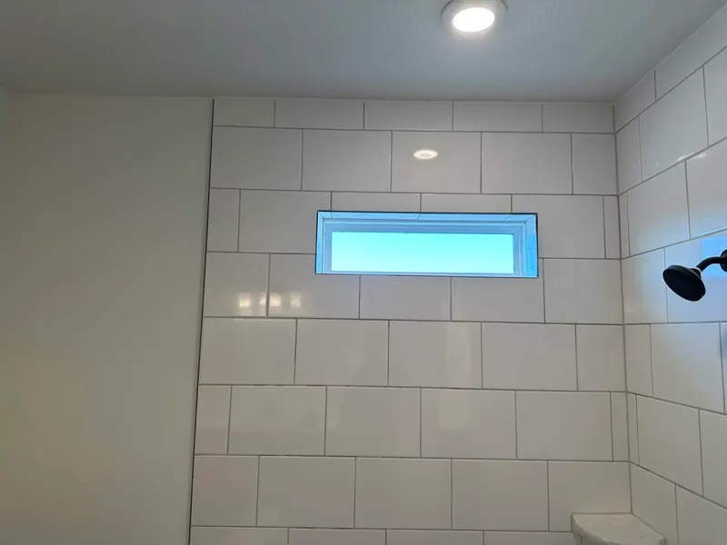 White subway tile shower with marble herringbone niche in Jacksonville FL